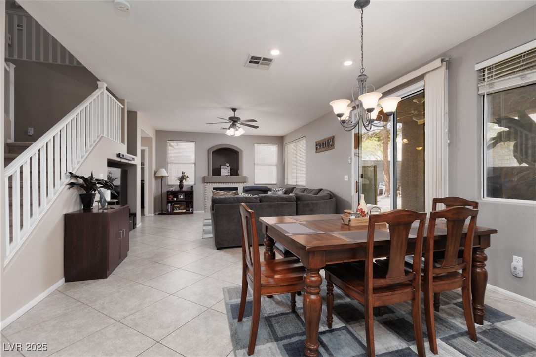 99 Milicity Road Henderson, NV 89012 - Photo 15 of 51 Dining area with a chandelier, a ceiling fan, stairway, light tile patterned floors, and recessed lighting