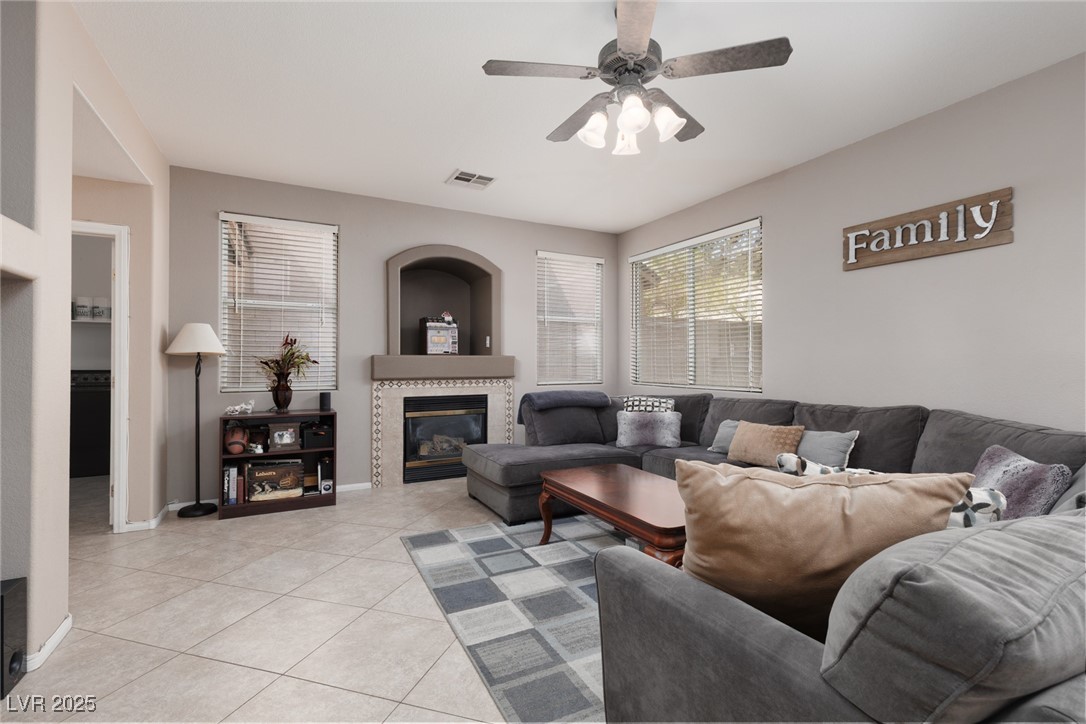 99 Milicity Road Henderson, NV 89012 - Photo 16 of 51 Living area featuring a tile fireplace, light tile patterned floors, and a ceiling fan