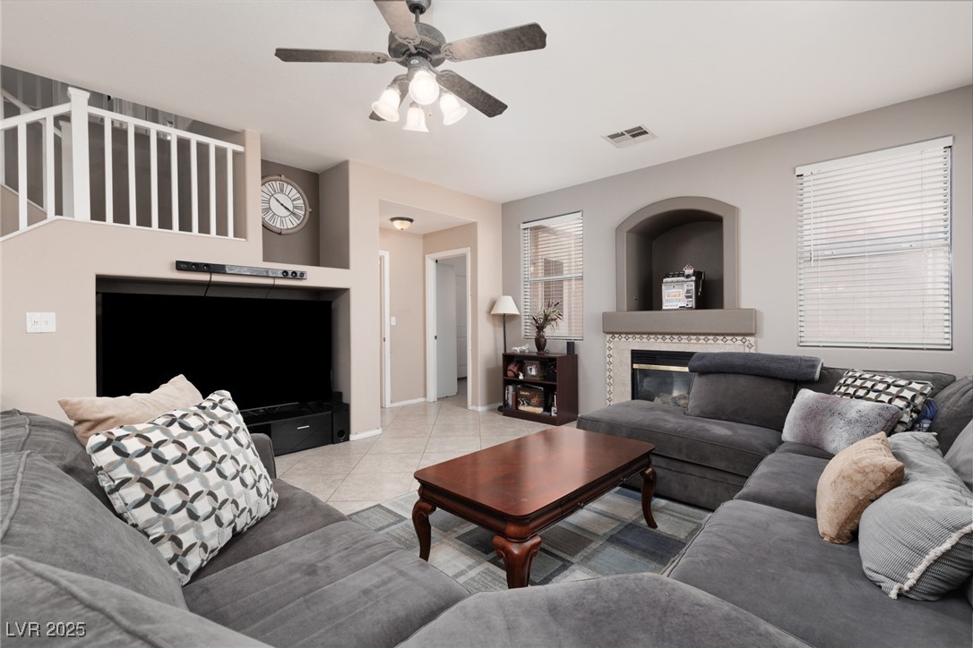 99 Milicity Road Henderson, NV 89012 - Photo 17 of 51 Tiled living area with a tiled fireplace and a ceiling fan
