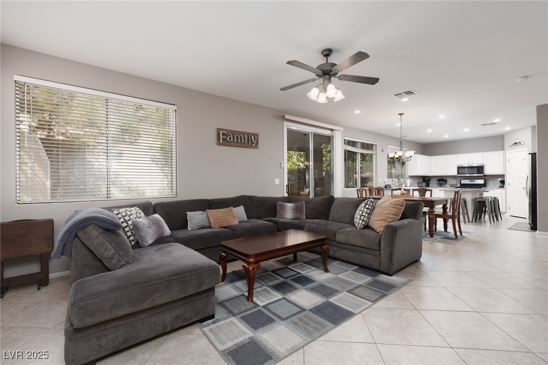 99 Milicity Road Henderson, NV 89012 - Photo 18 of 51 Living area with light tile patterned flooring, a chandelier, healthy amount of natural light, recessed lighting, and ceiling fan