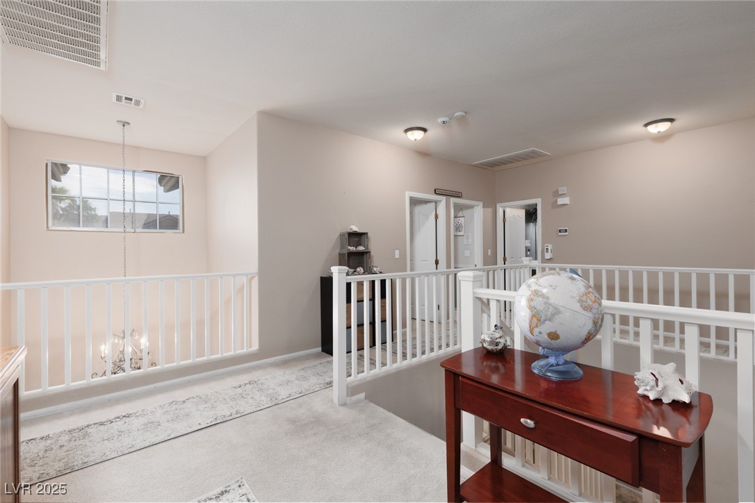 99 Milicity Road Henderson, NV 89012 - Photo 21 of 51 Corridor featuring carpet floors, a chandelier, and an upstairs landing