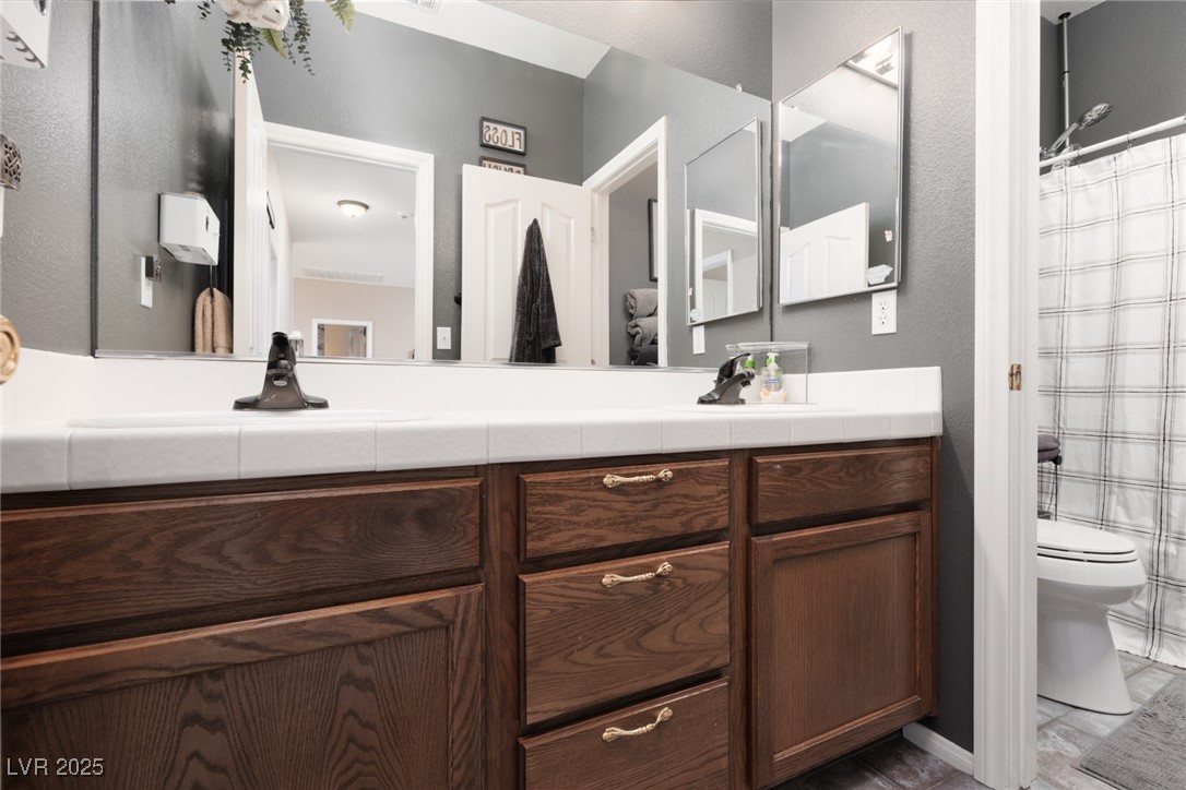99 Milicity Road Henderson, NV 89012 - Photo 23 of 51 Bathroom with vanity, a textured wall, and curtained shower