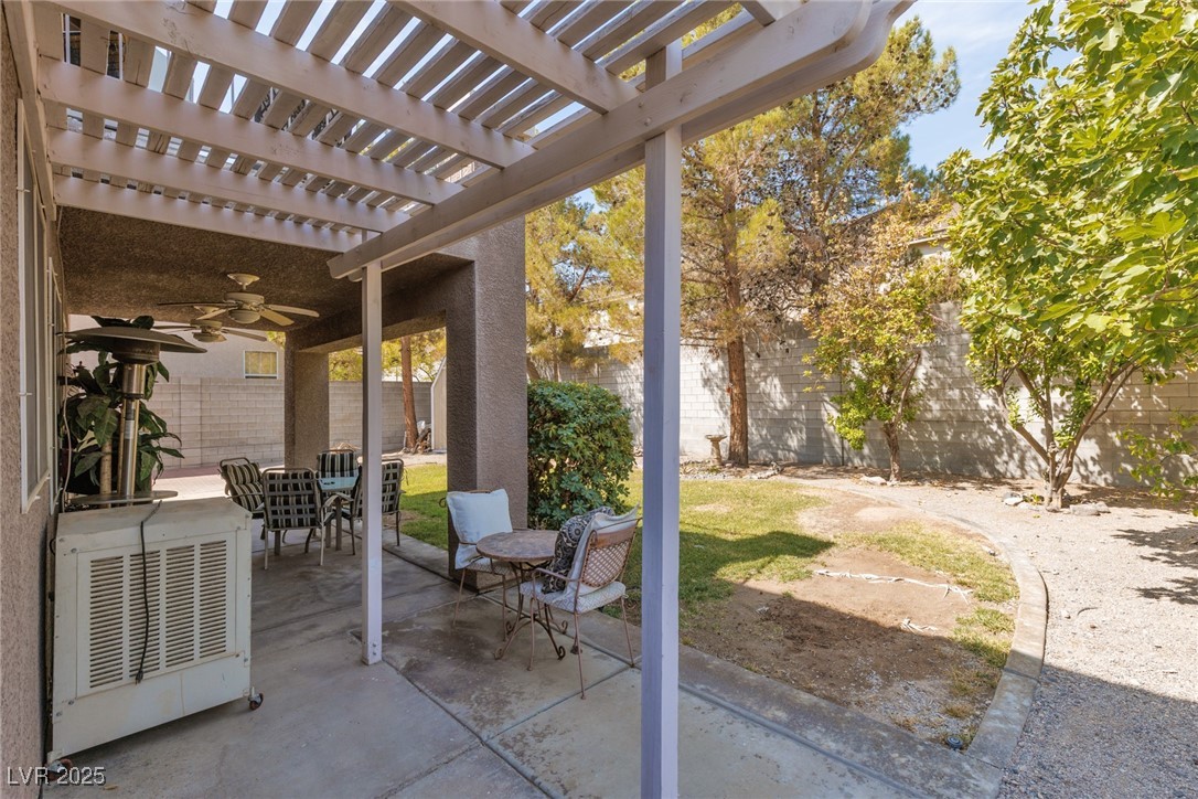 99 Milicity Road Henderson, NV 89012 - Photo 41 of 51 Fenced backyard with a ceiling fan, a patio area, a pergola, and outdoor dining area