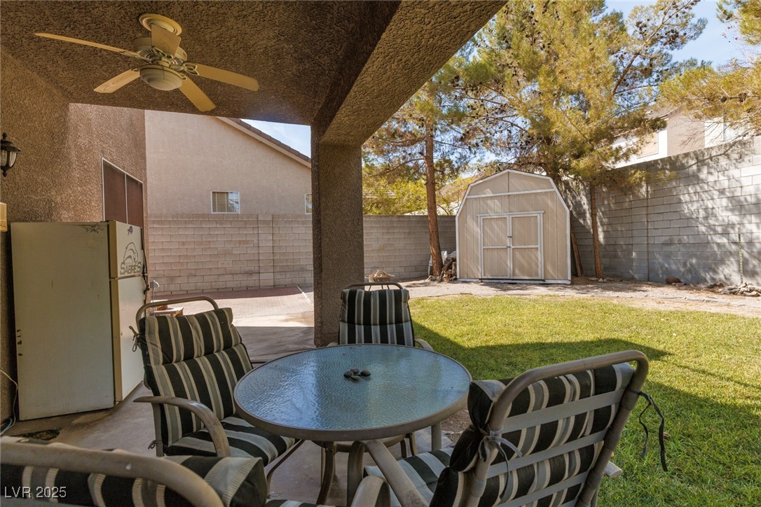 99 Milicity Road Henderson, NV 89012 - Photo 42 of 51 Fenced backyard with a patio area, a storage unit, and outdoor dining space