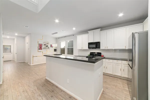 a kitchen with stainless steel appliances a sink stove top oven and refrigerator