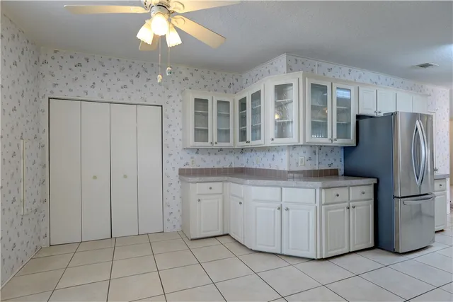 a kitchen with granite countertop white cabinets and white appliances