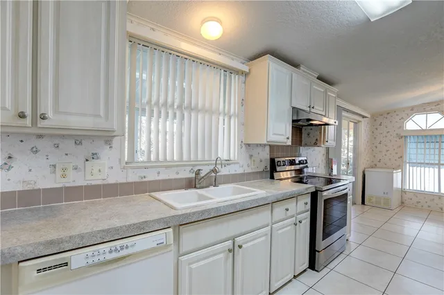 a kitchen with stainless steel appliances granite countertop a sink stove and cabinets