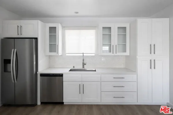 a kitchen with white cabinets and stainless steel appliances
