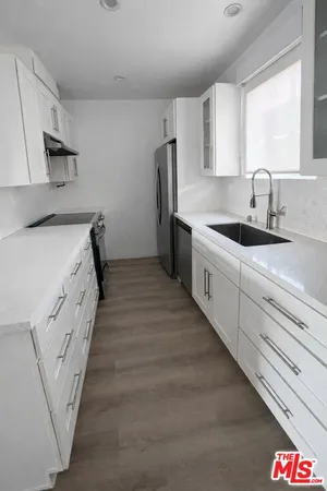 a kitchen with stainless steel appliances a sink stove and refrigerator