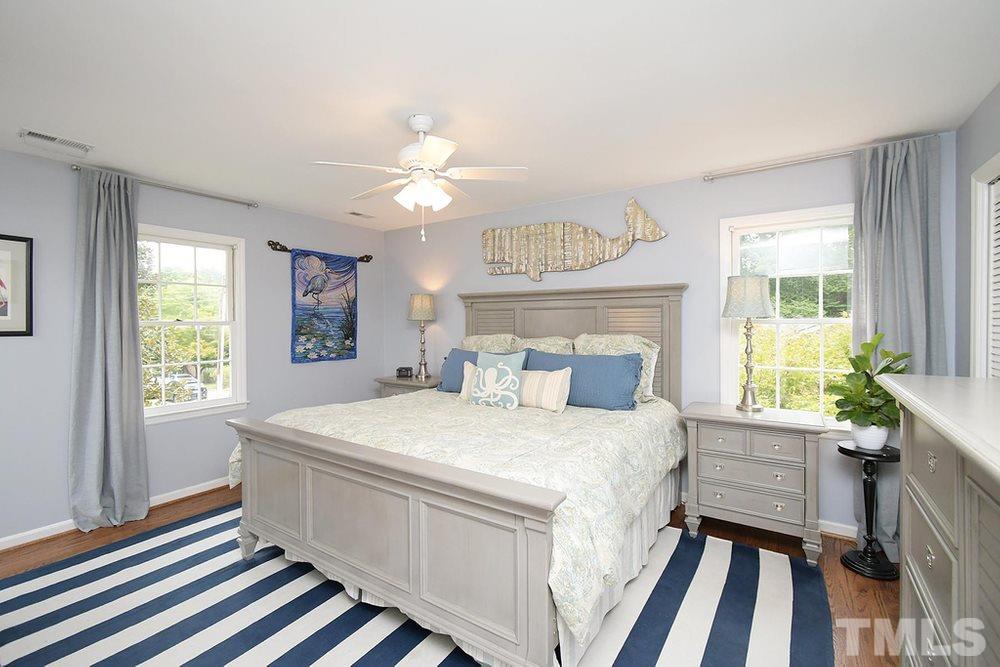 6405 Wrenwood Avenue Raleigh, NC 27607 - Photo 13 of 30 a bedroom with a bed a chandelier and a window