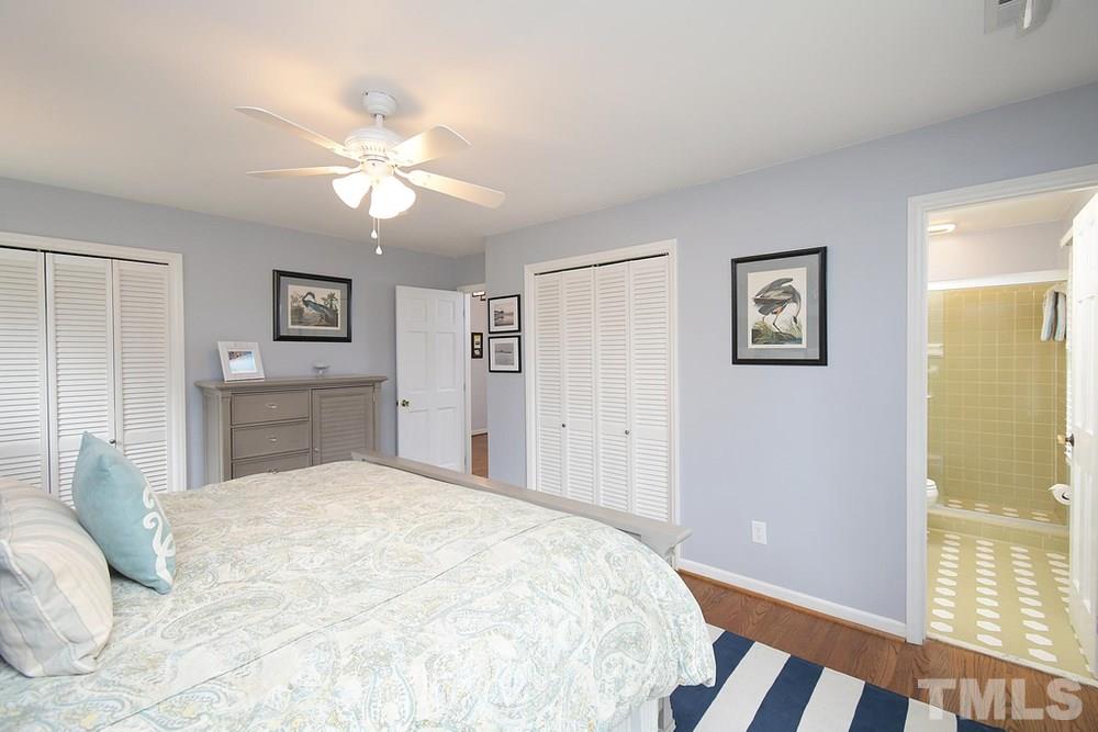 6405 Wrenwood Avenue Raleigh, NC 27607 - Photo 14 of 30 a bedroom with a large bed and a chandelier