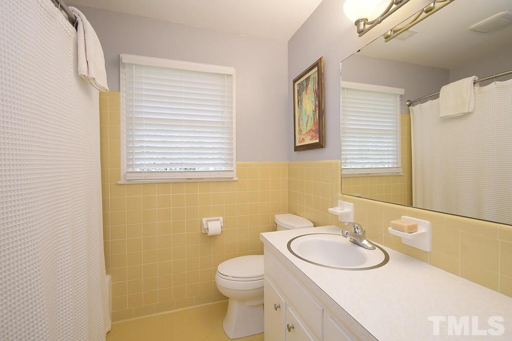 6405 Wrenwood Avenue Raleigh, NC 27607 - Photo 21 of 30 a bathroom with a sink a toilet and mirror
