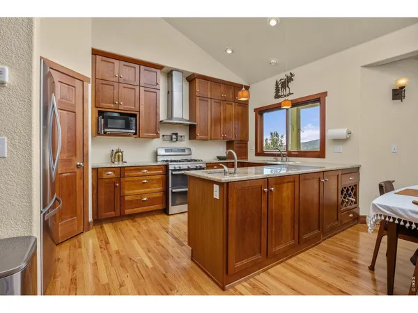 a kitchen with stainless steel appliances granite countertop a refrigerator a stove top oven a sink and dishwasher