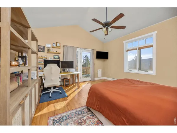 a bed room with a bed a window and a ceiling fan