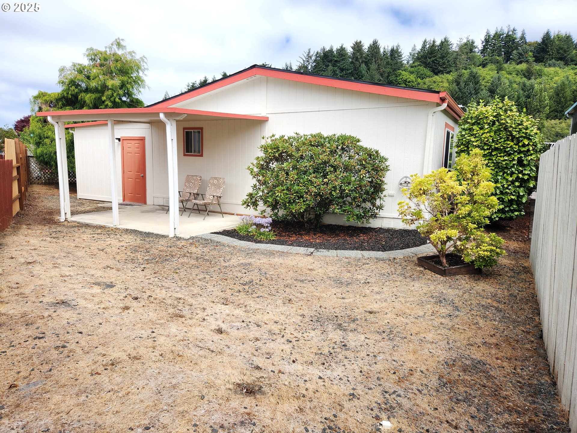 100 River Bend Road, Unit 103 Reedsport, OR 97467 - Photo 7 of 26 a front view of a house with a yard and garage