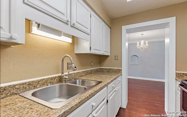 a kitchen with granite countertop a sink and a wooden cabinets