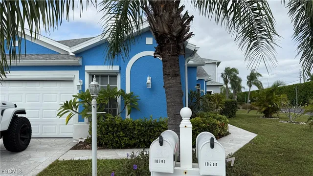 a vase of flowers sitting on a yard in front of a house