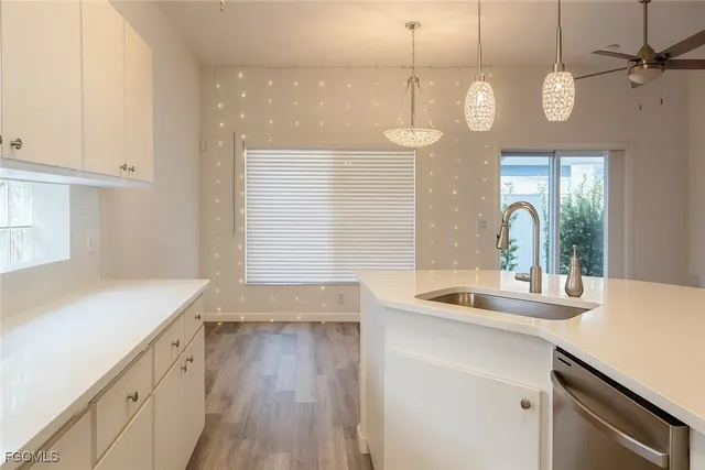 a kitchen with a sink stove and wooden floor