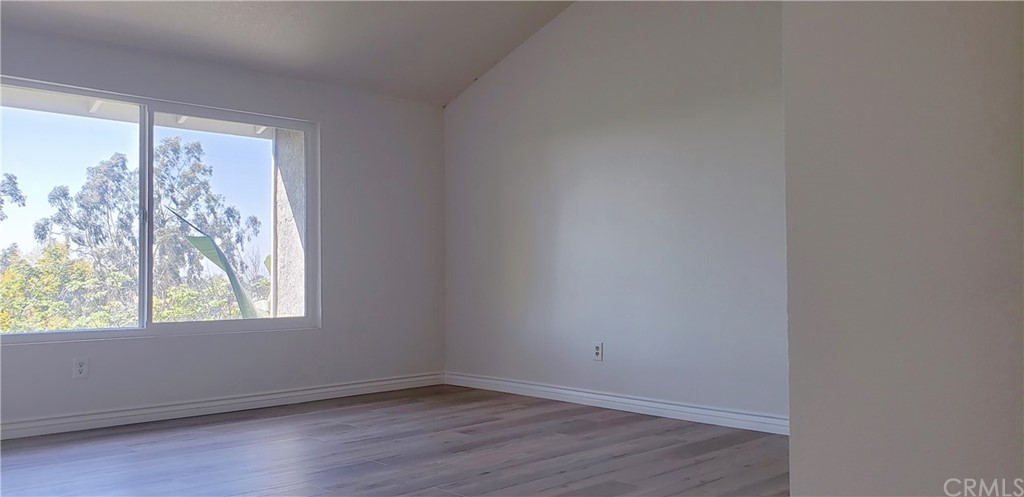 33 Valley, Unit 35 Irvine, CA 92612 - Photo 16 of 31 an empty room with wooden floor and windows