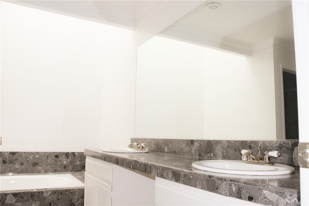 33 Valley, Unit 35 Irvine, CA 92612 - Photo 19 of 31 a bathroom with a granite countertop sink and a mirror