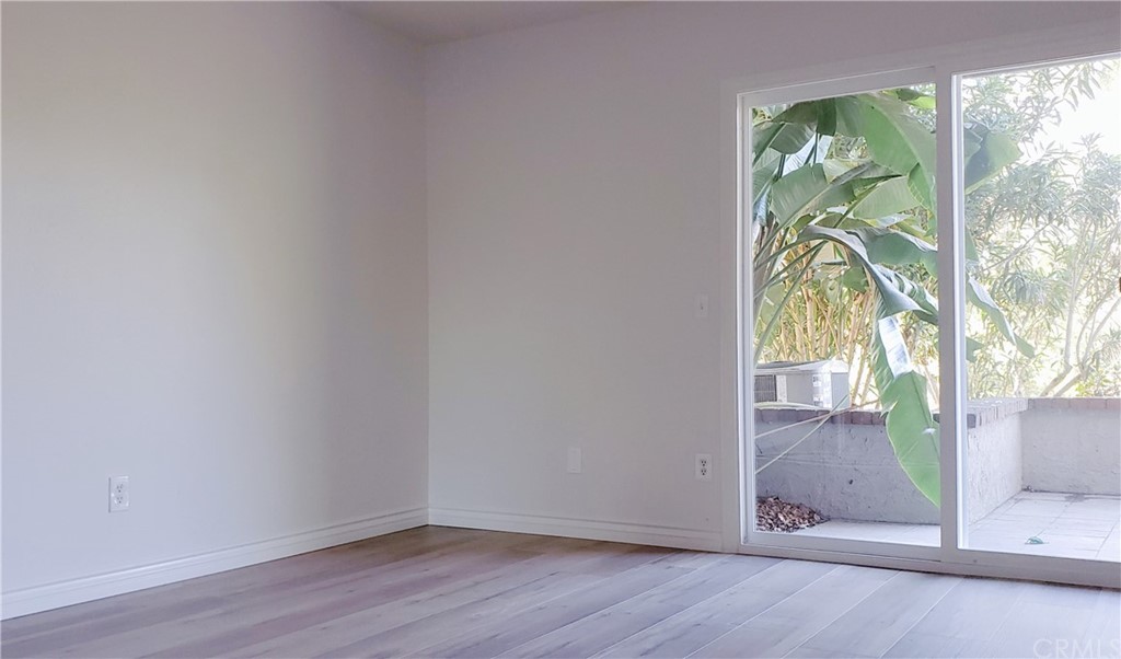 33 Valley, Unit 35 Irvine, CA 92612 - Photo 24 of 31 an empty room with wooden floor and windows