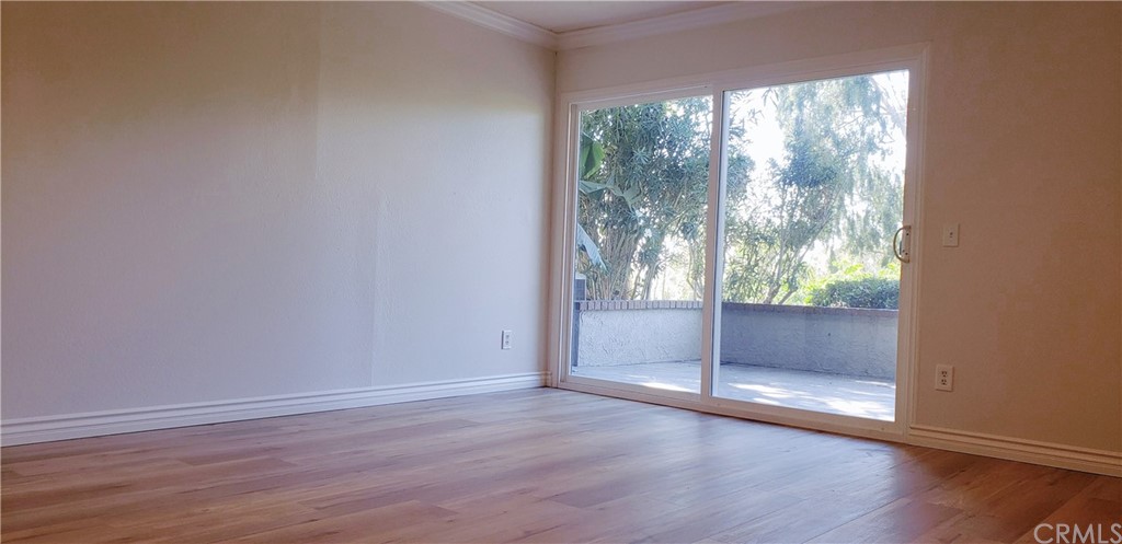 33 Valley, Unit 35 Irvine, CA 92612 - Photo 25 of 31 an empty room with wooden floor and windows