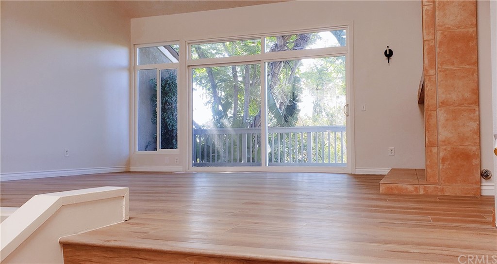 33 Valley, Unit 35 Irvine, CA 92612 - Photo 6 of 31 a view of a room with wooden floor and a floor to ceiling window