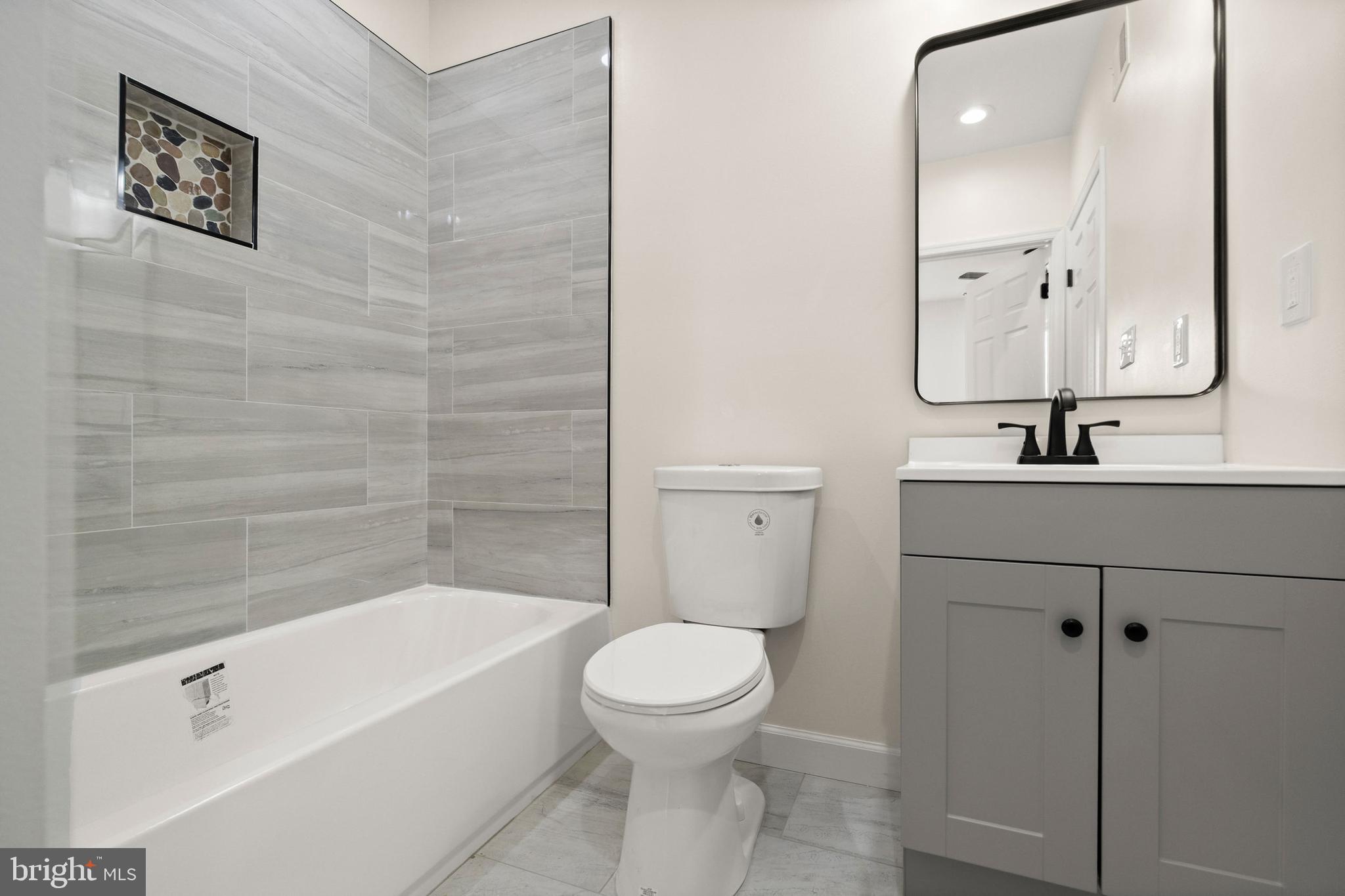 2815 West Cold Spring Lane Baltimore, MD 21215 - Photo 15 of 37 a bathroom with a bathtub shower sink mirror and toilet