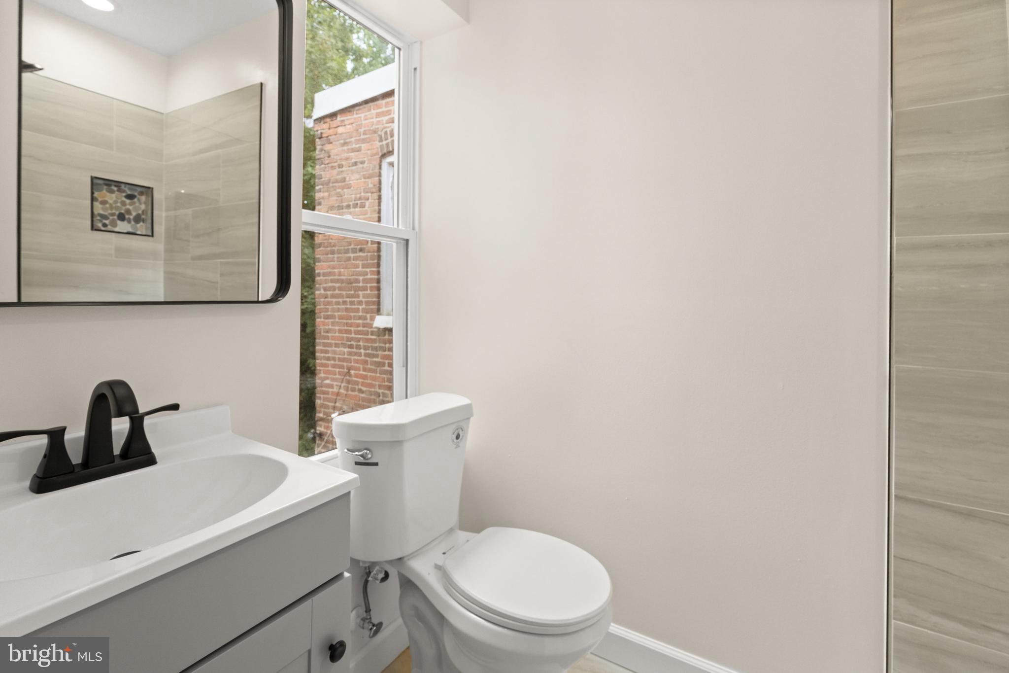 2815 West Cold Spring Lane Baltimore, MD 21215 - Photo 22 of 37 a bathroom with a toilet sink and mirror