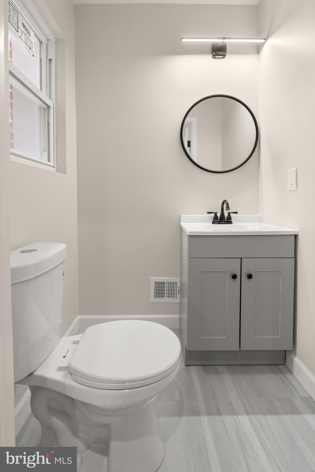 2815 West Cold Spring Lane Baltimore, MD 21215 - Photo 9 of 37 a bathroom with a toilet a sink and mirror
