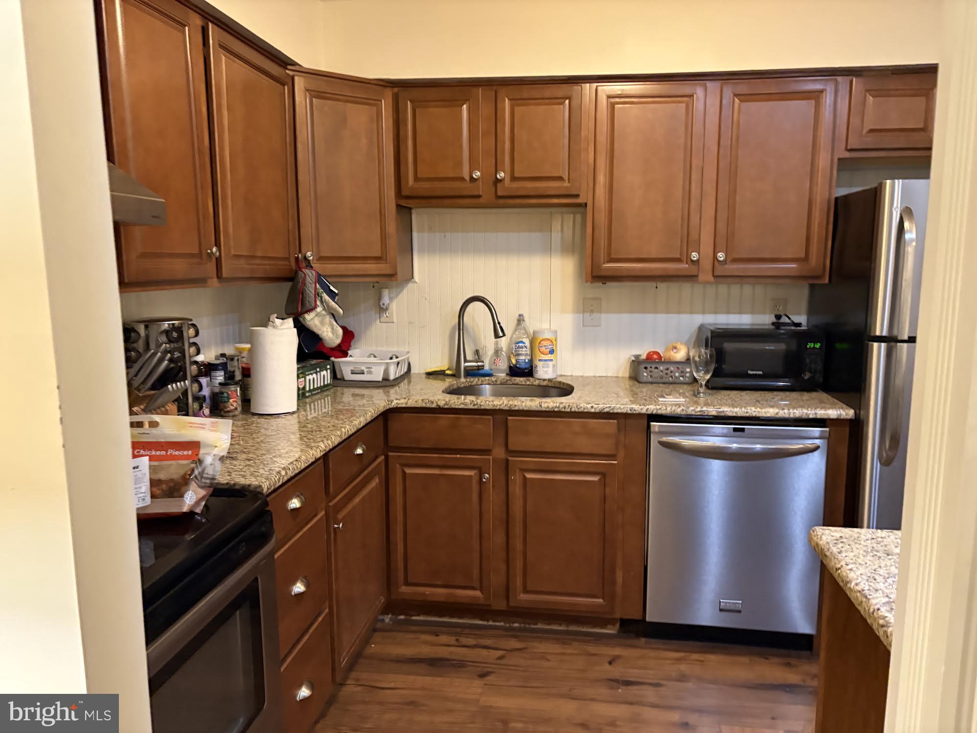 7 Rockford Road, Unit E12 Wilmington, DE 19806 - Photo 8 of 17 a kitchen with stainless steel appliances granite countertop a refrigerator sink and cabinets