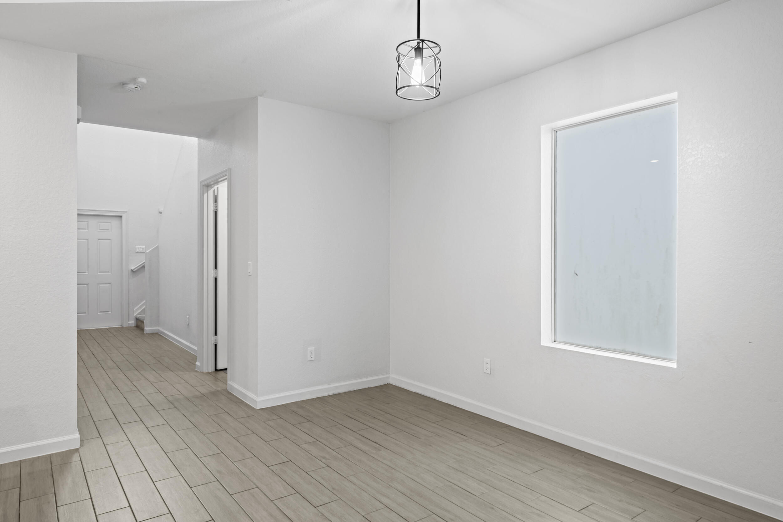 738 Worlington Lane Fort Pierce, FL 34947 - Photo 13 of 69 wooden floor in an empty room with a window