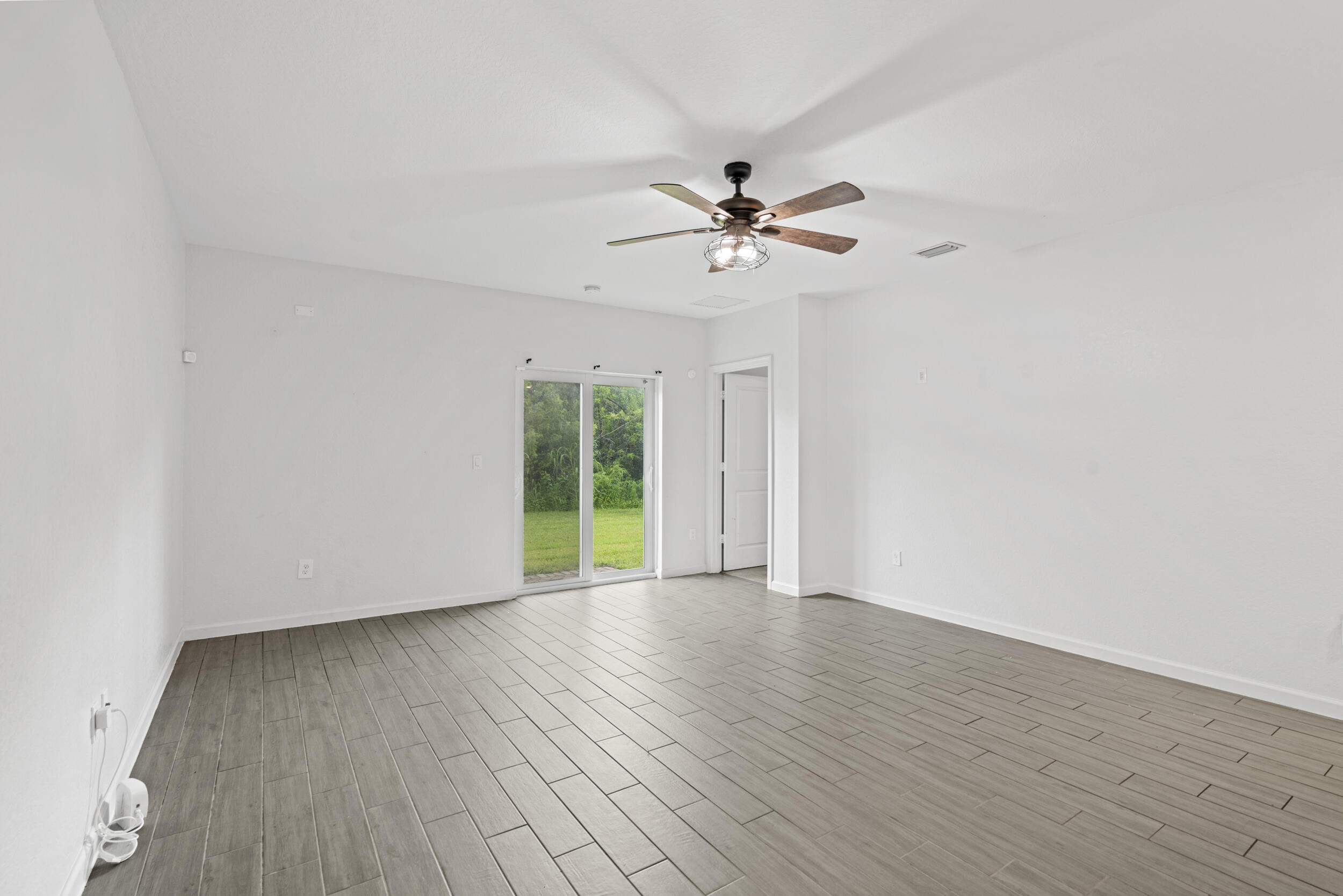 738 Worlington Lane Fort Pierce, FL 34947 - Photo 16 of 69 a view of an empty room with a window and wooden floor