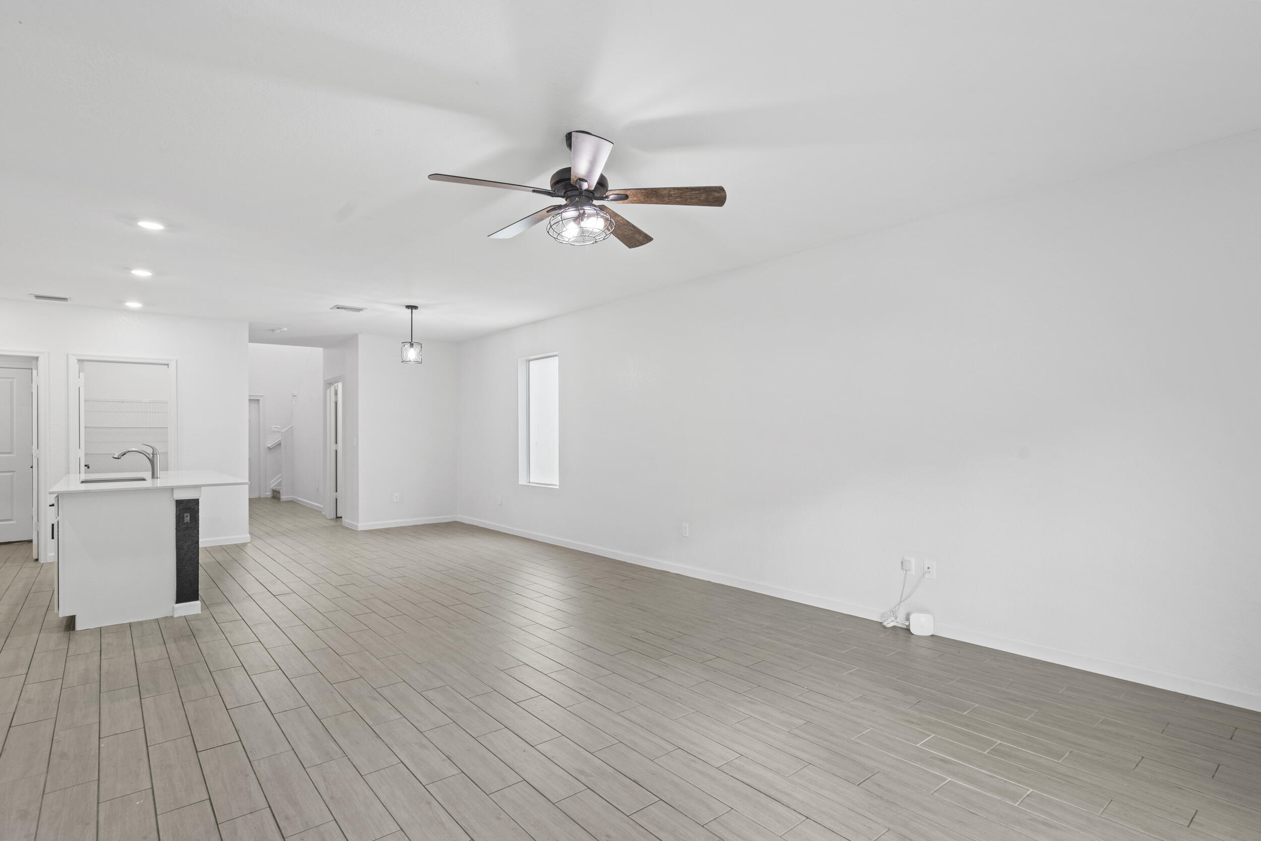 738 Worlington Lane Fort Pierce, FL 34947 - Photo 19 of 69 a view of an empty room with wooden floor and a kitchen