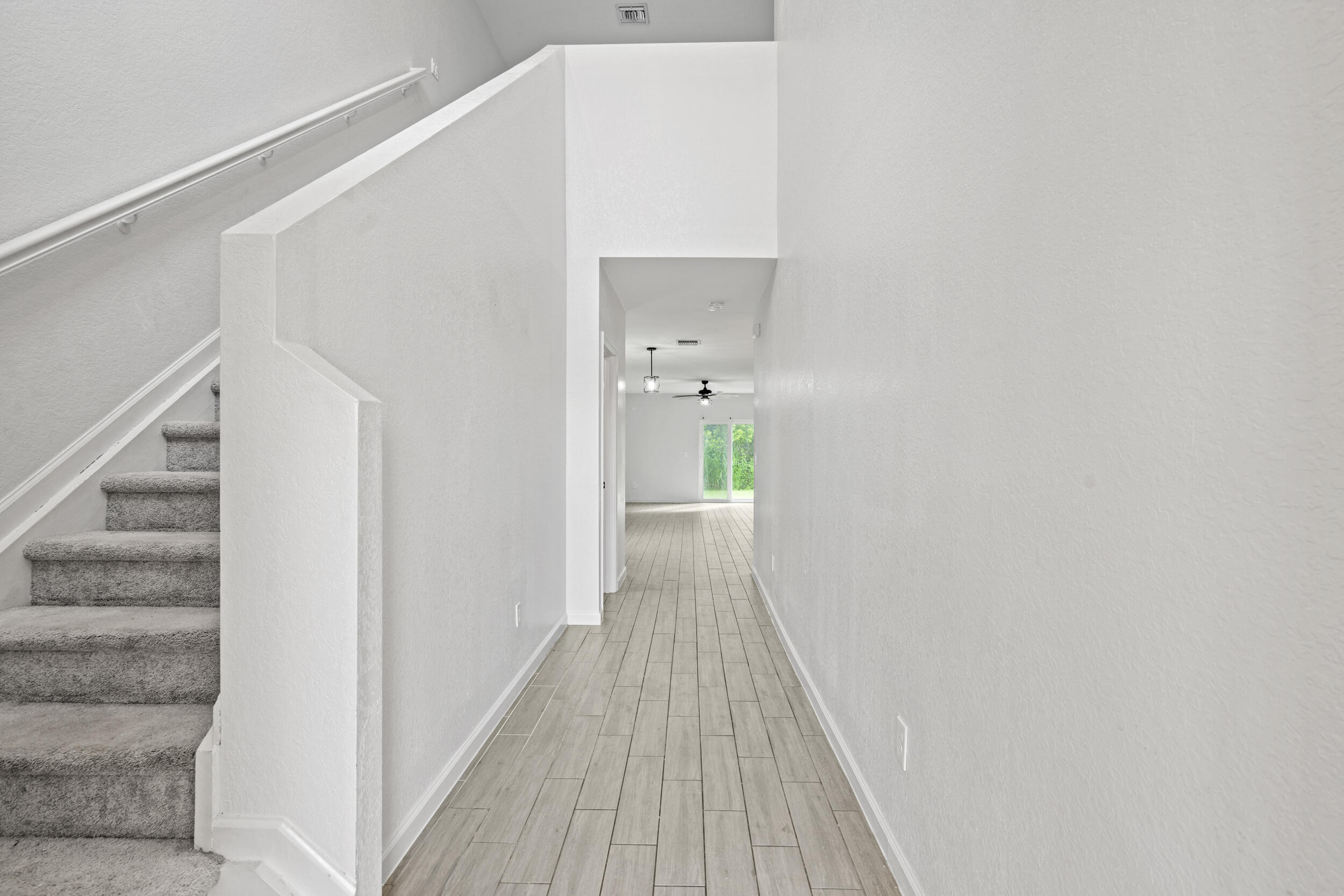 738 Worlington Lane Fort Pierce, FL 34947 - Photo 3 of 69 a view of a hallway with wooden floor and staircase