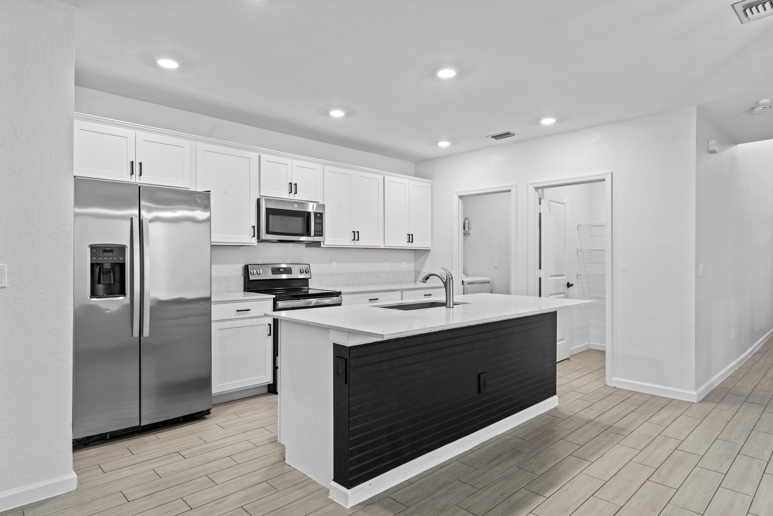 738 Worlington Lane Fort Pierce, FL 34947 - Photo 9 of 69 a kitchen with kitchen island a sink stainless steel appliances and cabinets