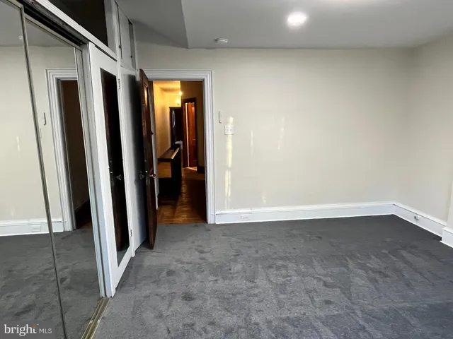 a view of a room with wooden floor and a bathroom