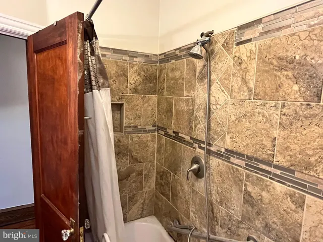 a view of an empty room with wooden floor and closet