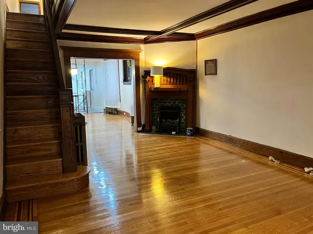 a view of a livingroom with wooden floor and a ceiling fan