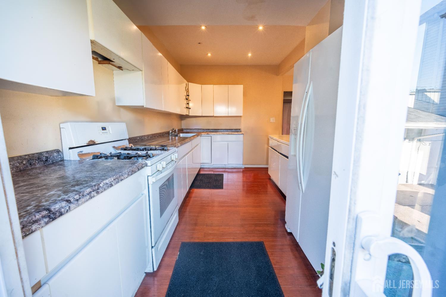 269 Silzer Street Perth Amboy, NJ 08861 - Photo 5 of 13 a kitchen with stainless steel appliances granite countertop a refrigerator and a stove