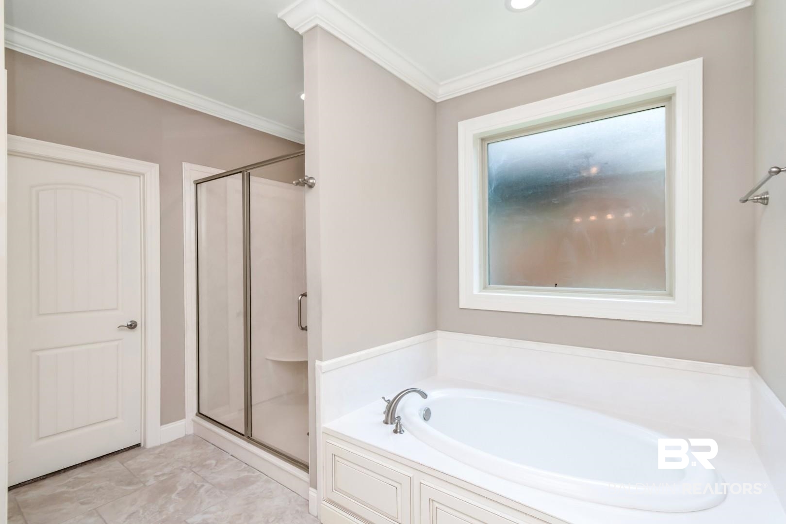 3528 Rue Royal Mobile, AL 36693 - Photo 28 of 53 Built-in garden tub with deck-mounted faucet, framed window, glass-enclosed shower, tiled flooring, and crown molding