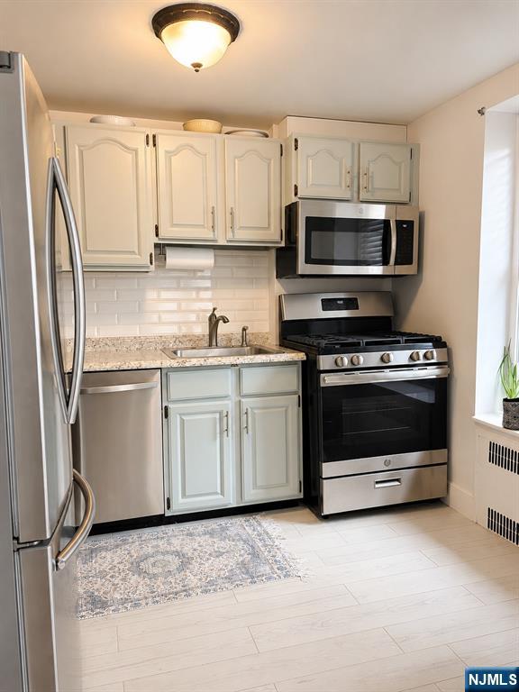 100 Prospect Avenue, Unit 5H Hackensack, NJ 07601 - Photo 9 of 17 a kitchen with stainless steel appliances granite countertop a stove a sink and a refrigerator