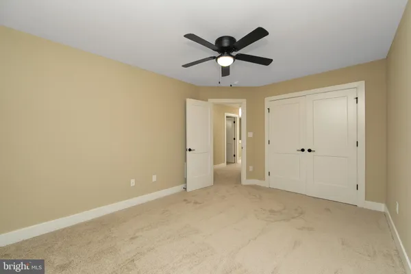 an empty room with ceiling fan and window
