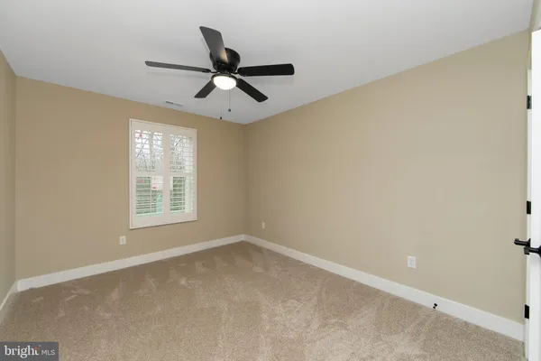 an empty room with a ceiling fan and a window
