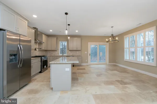 a kitchen with stainless steel appliances granite countertop a sink a stove a refrigerator and cabinets