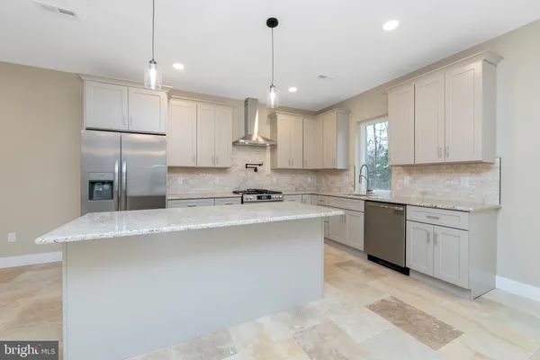 a large kitchen with kitchen island a sink stainless steel appliances and cabinets