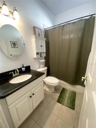 a bathroom with a granite countertop sink a mirror and a toilet