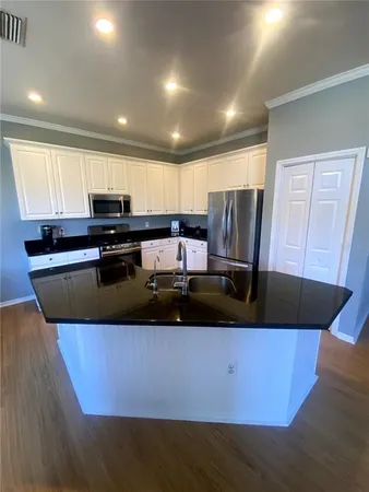 a kitchen with stainless steel appliances granite countertop a sink a stove a refrigerator a microwave and cabinets