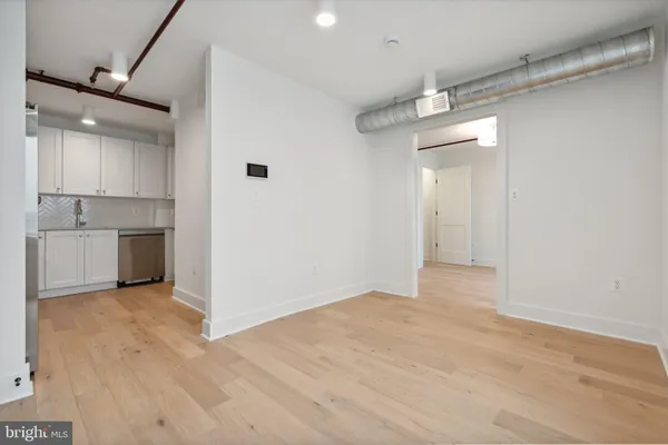 a view of a kitchen with a sink and wooden cabinet