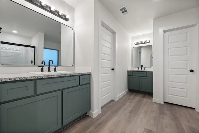 a bathroom with a granite countertop sink double vanity and a mirror